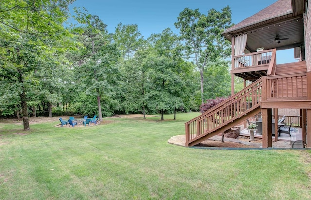 32 Bronte Ct, Little Rock, AR 72223 - view of grassy yard featuring stairway, a wooden deck, a ceiling fan, an outdoor fire pit, and view of wooded area