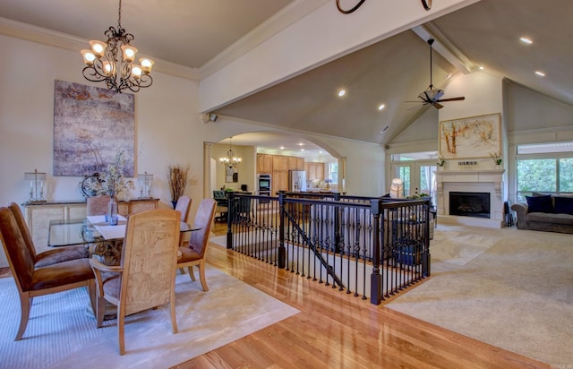 32 Bronte Ct, Little Rock, AR 72223 - dining room featuring a chandelier, a large fireplace, arched walkways, light wood-style flooring, and high vaulted ceiling
