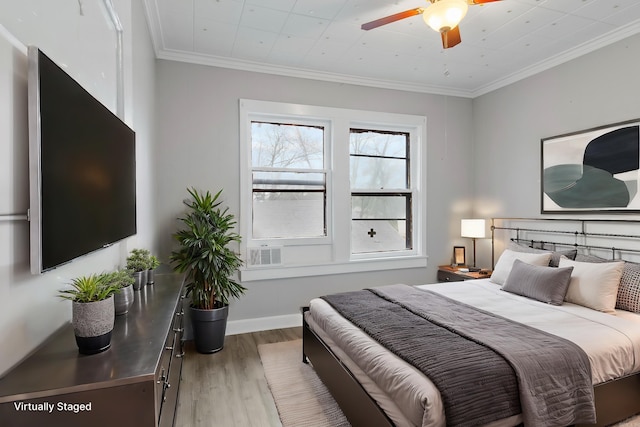 bedroom with wood finished floors, crown molding, and ceiling fan