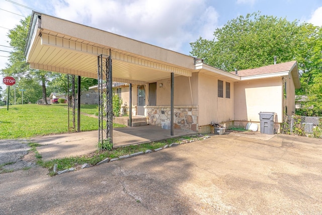 2616 Stallings Ln, Jonesboro, AR 72401 - back of property featuring stone siding, a yard, covered porch, and stucco siding