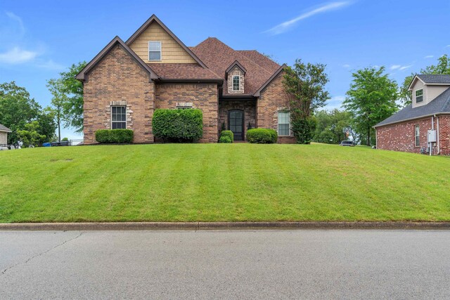 view of front facade featuring a front yard and brick siding