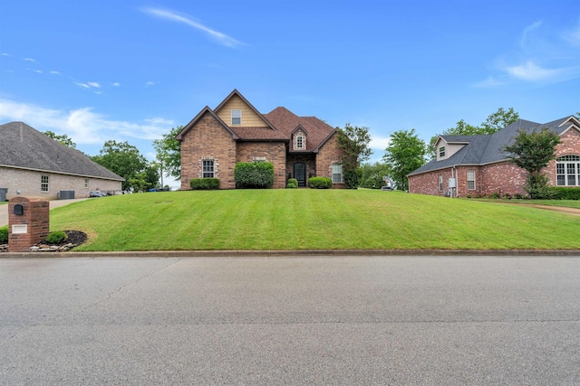 view of front of home featuring a front yard, stone siding, and brick siding