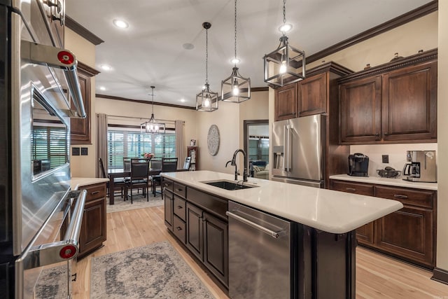 kitchen featuring stainless steel appliances, a sink, ornamental molding, light countertops, and dark brown cabinetry