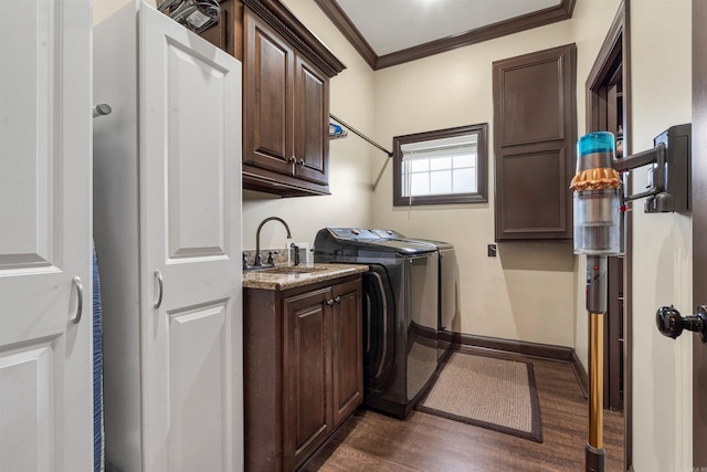 laundry room with cabinet space, washing machine and dryer, ornamental molding, dark wood-style flooring, and baseboards