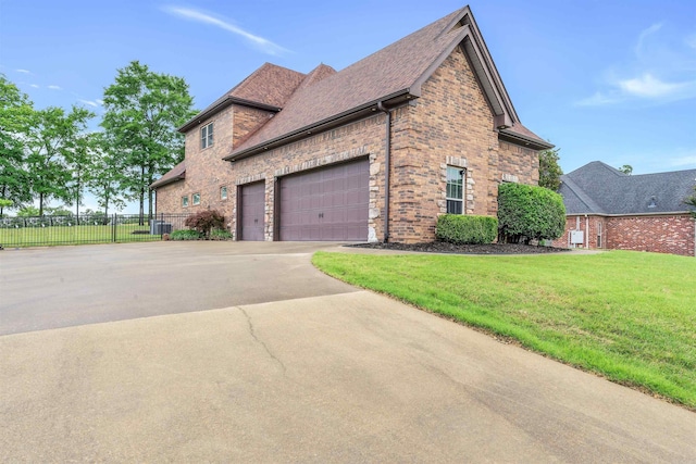 view of side of property featuring brick siding, driveway, an attached garage, and roof with shingles