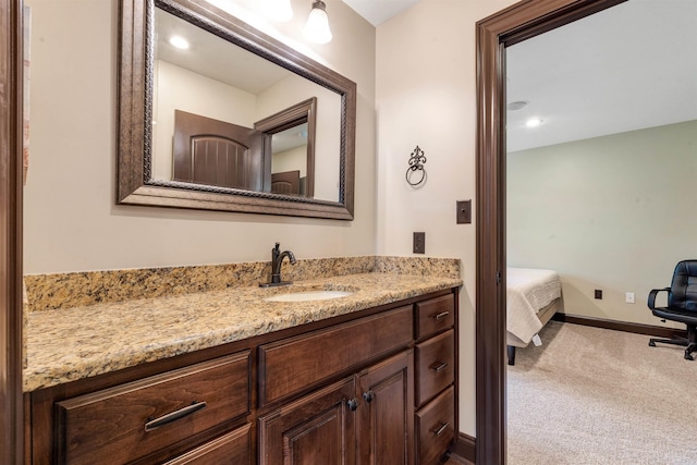ensuite bathroom with vanity and baseboards