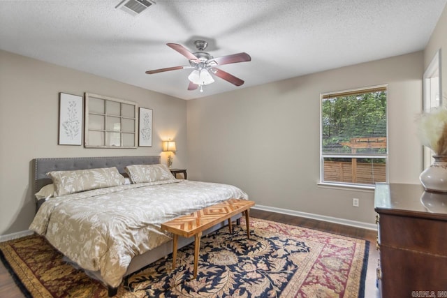 3311 Hazy Ridge Ct, Little Rock, AR 72227 - bedroom featuring dark wood-type flooring, baseboards, a textured ceiling, and a ceiling fan