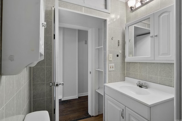 503 N Walnut St, Searcy, AR 72143 - bathroom featuring tile walls, wood finished floors, vanity, and decorative backsplash