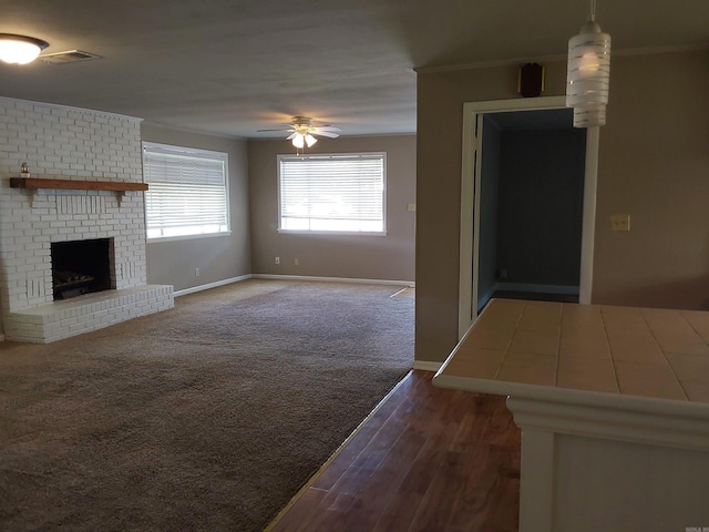 3810 Congo Rd, Benton, AR 72019 - unfurnished living room with ornamental molding, a ceiling fan, a brick fireplace, baseboards, and wood finished floors