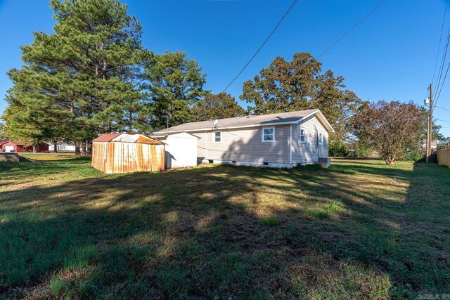 3907 Gamblin Dr, Jonesboro, AR 72404 - back of property with a storage shed, a lawn, an outbuilding, and crawl space