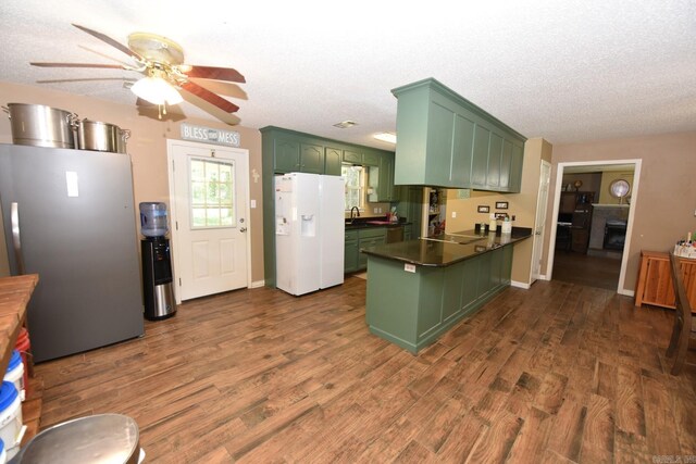 22 Primrose Ln, Greenbrier, AR 72058 - kitchen featuring green cabinetry, white fridge with ice dispenser, a peninsula, freestanding refrigerator, and a sink