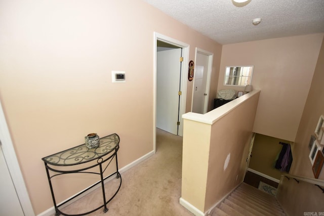 22 Primrose Ln, Greenbrier, AR 72058 - hallway featuring carpet, a textured ceiling, baseboards, and an upstairs landing