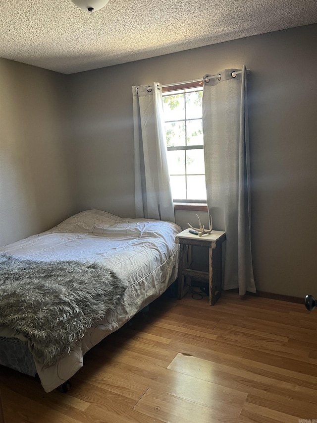 911 Apple Rd, Bonnerdale, AR 71933 - bedroom with wood finished floors and a textured ceiling