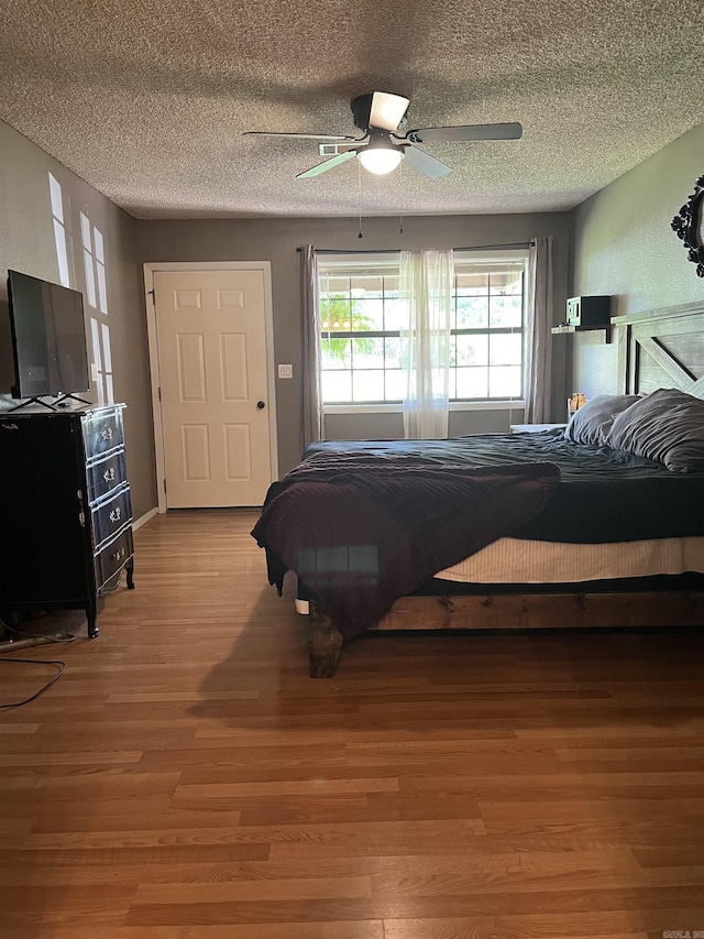 911 Apple Rd, Bonnerdale, AR 71933 - bedroom featuring wood finished floors, a textured ceiling, and ceiling fan