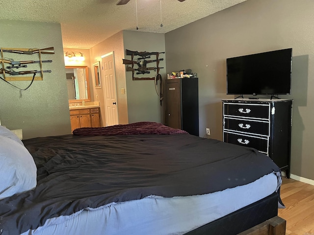911 Apple Rd, Bonnerdale, AR 71933 - bedroom featuring light wood-style flooring, ensuite bathroom, and a textured ceiling