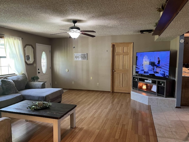 911 Apple Rd, Bonnerdale, AR 71933 - living area featuring light wood-style flooring, a ceiling fan, a textured ceiling, and baseboards