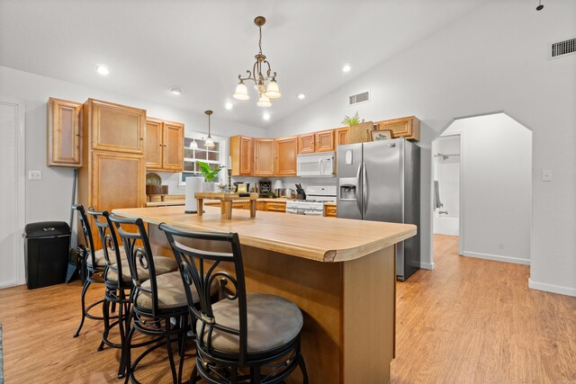 67 Delton Mccauley Rd, Kirby, AR 71950 - kitchen featuring white appliances, light countertops, light wood-type flooring, vaulted ceiling, and pendant lighting
