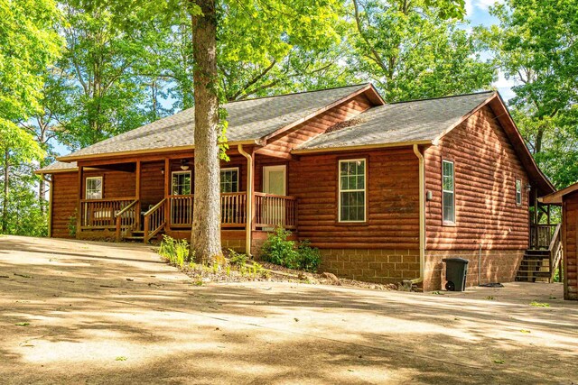 67 Delton Mccauley Rd, Kirby, AR 71950 - rustic home featuring a porch, stairway, log veneer siding, concrete driveway, and roof with shingles