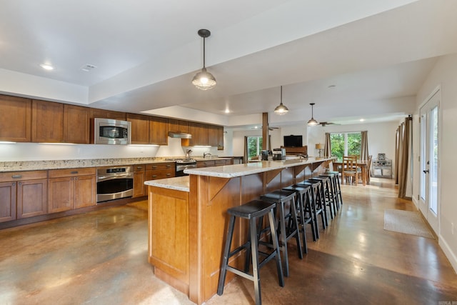 15364 Twin Pines Rd, Lowell, AR 72745 - kitchen with stainless steel appliances, finished concrete floors, brown cabinets, light stone counters, and recessed lighting