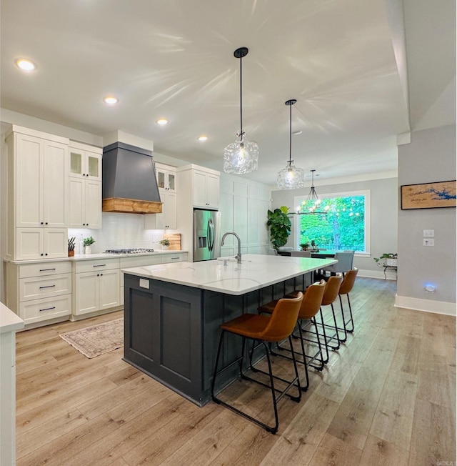 816 Nature Way, Benton, AR 72019 - kitchen with custom exhaust hood, stainless steel appliances, white cabinetry, light wood-type flooring, and recessed lighting