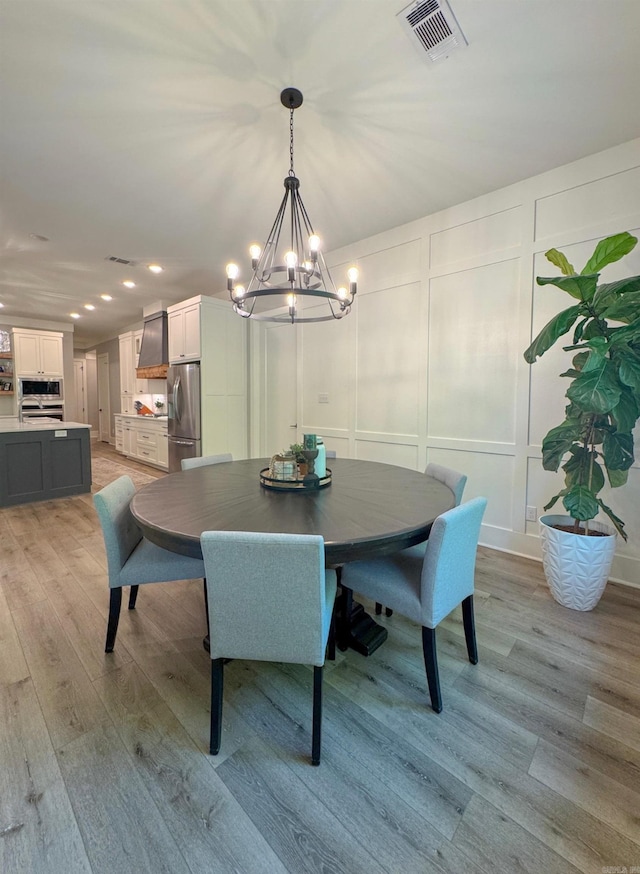 816 Nature Way, Benton, AR 72019 - dining room featuring a chandelier, a decorative wall, recessed lighting, and light wood-type flooring
