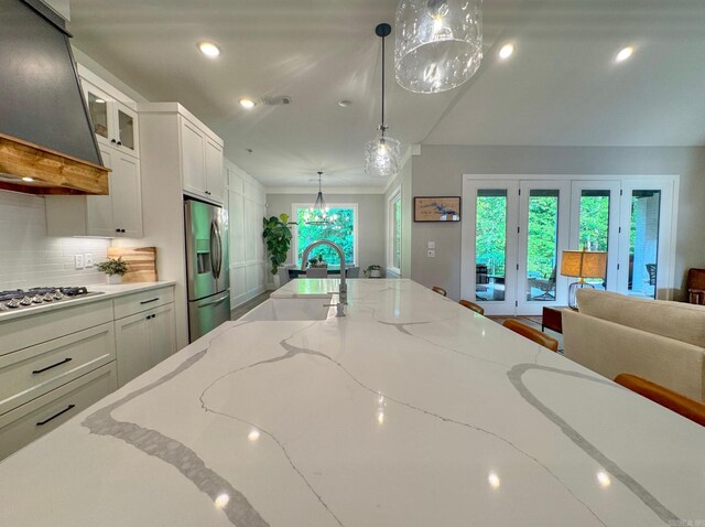 816 Nature Way, Benton, AR 72019 - kitchen with stainless steel appliances, ventilation hood, a sink, white cabinets, and light stone countertops