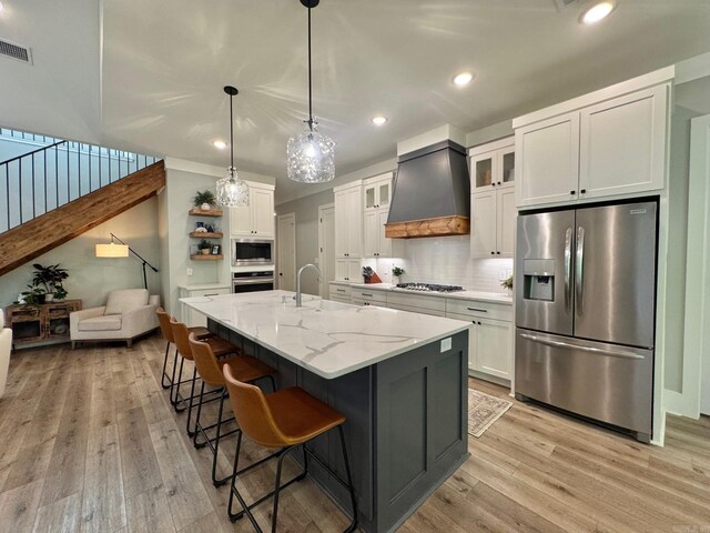 816 Nature Way, Benton, AR 72019 - kitchen featuring stainless steel appliances, custom range hood, light wood finished floors, white cabinets, and recessed lighting