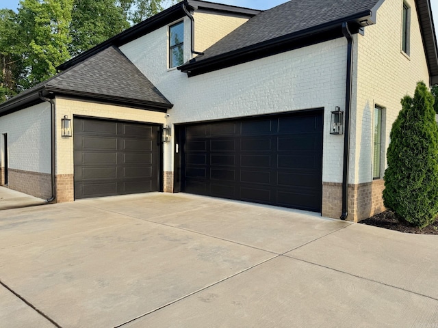 816 Nature Way, Benton, AR 72019 - view of home's exterior with brick siding, an attached garage, a shingled roof, and concrete driveway