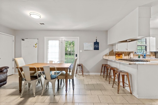dining room with plenty of natural light, baseboards, and light tile patterned flooring