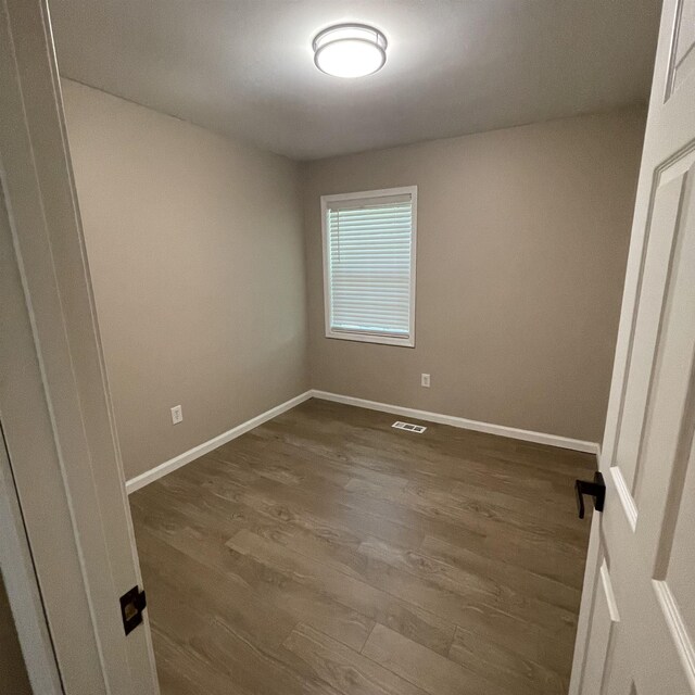 1302-1304 Santa Fe, Jonesboro, AR 72401 - spare room with dark wood-style flooring and baseboards