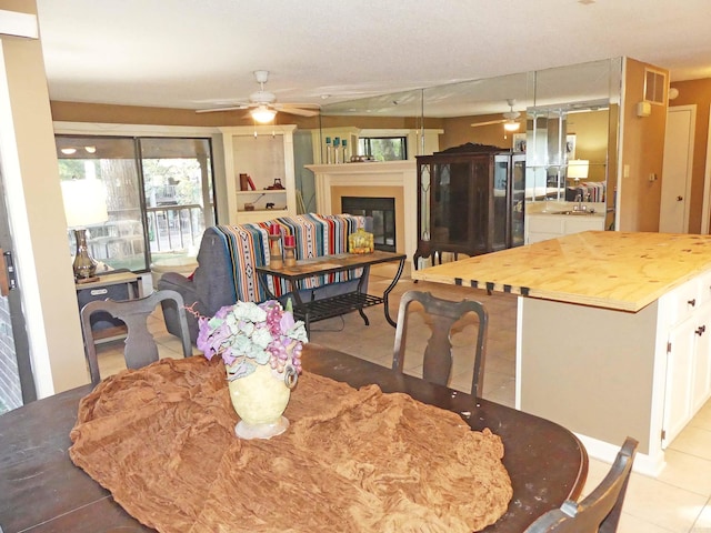 2325 Lakeshore Unit E-4, Hot Springs, AR 71913 - dining room featuring a ceiling fan, a glass covered fireplace, and light tile patterned floors