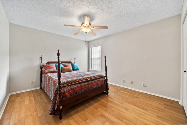 2325 Lakeshore Unit E-4, Hot Springs, AR 71913 - bedroom with light wood-type flooring, a textured ceiling, baseboards, and a ceiling fan