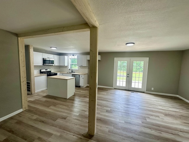 27 Grant 491 Rd, Sheridan, AR 72105 - kitchen featuring stainless steel appliances, french doors, a kitchen island, backsplash, and light wood-style flooring