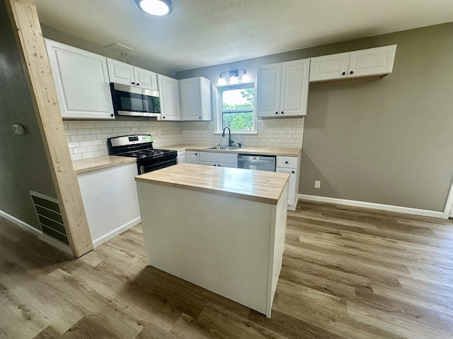 27 Grant 491 Rd, Sheridan, AR 72105 - kitchen with stainless steel appliances, a sink, butcher block counters, and white cabinetry
