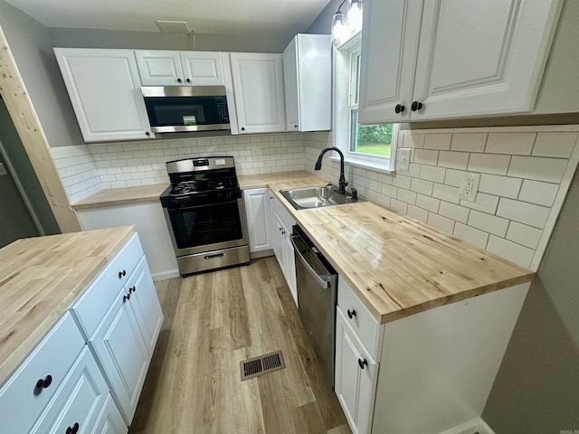 27 Grant 491 Rd, Sheridan, AR 72105 - kitchen with butcher block counters, stainless steel appliances, a sink, and light wood-style floors