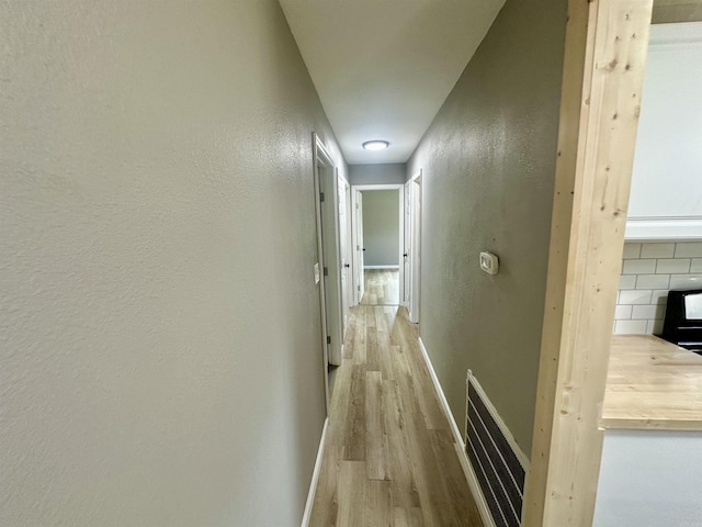 27 Grant 491 Rd, Sheridan, AR 72105 - hallway featuring light wood-type flooring, a textured wall, and baseboards