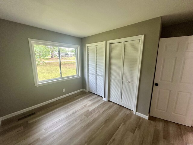 27 Grant 491 Rd, Sheridan, AR 72105 - unfurnished bedroom with wood finished floors, baseboards, and multiple closets
