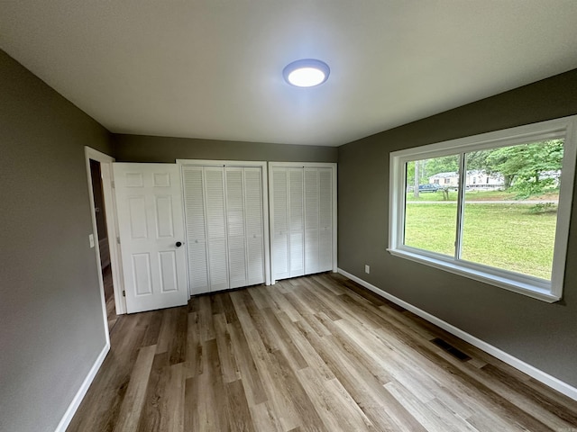 27 Grant 491 Rd, Sheridan, AR 72105 - unfurnished bedroom featuring multiple closets, baseboards, and wood finished floors