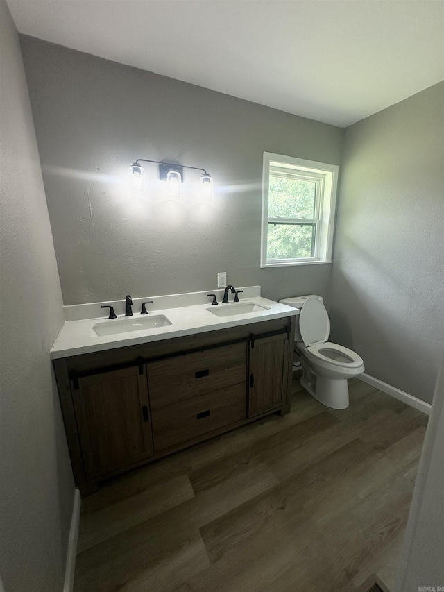 27 Grant 491 Rd, Sheridan, AR 72105 - bathroom featuring toilet, wood finished floors, double vanity, and baseboards