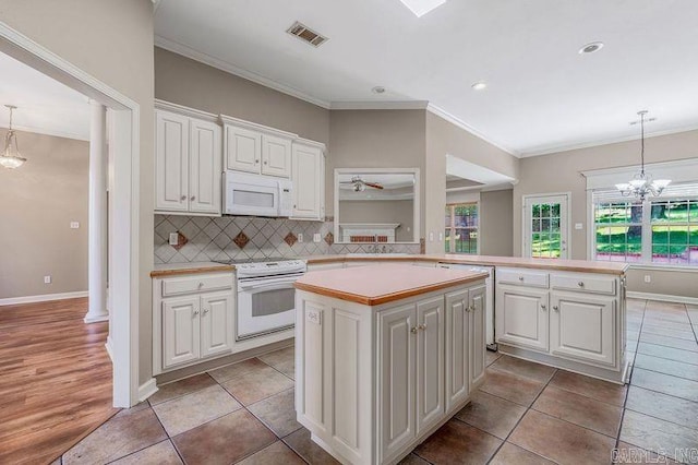 1010 Claycut Cir, North Little Rock, AR 72116 - kitchen with white appliances, a kitchen island, light countertops, crown molding, and white cabinetry