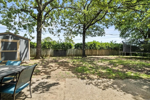 42 Desoto Cir, North Little Rock, AR 72116 - view of yard featuring a trampoline, fence, a storage unit, an outdoor structure, and outdoor dining area