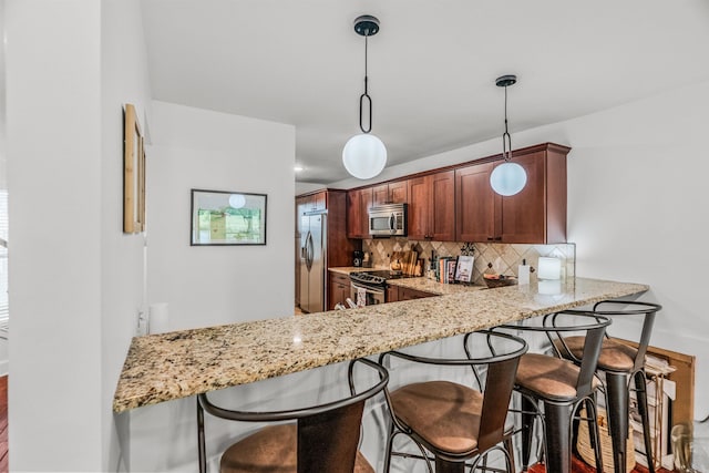 2510 Riverfront # 2, Little Rock, AR 72202 - kitchen featuring appliances with stainless steel finishes, backsplash, light stone counters, and pendant lighting