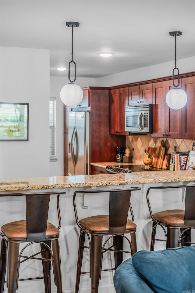 2510 Riverfront # 2, Little Rock, AR 72202 - kitchen with stainless steel appliances, a kitchen bar, backsplash, and light stone counters
