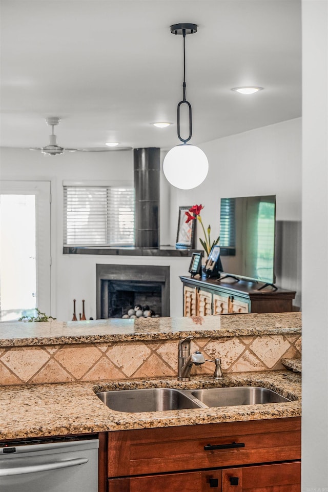 2510 Riverfront # 2, Little Rock, AR 72202 - kitchen with a sink, stainless steel dishwasher, light stone counters, and brown cabinets