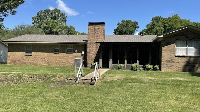 1410 Rock Creek Dr, Benton, AR 72019 - rear view of property featuring a chimney, brick siding, a lawn, a shingled roof, and a sunroom