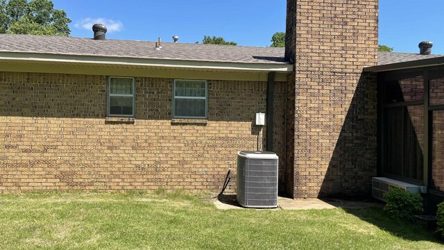 1410 Rock Creek Dr, Benton, AR 72019 - view of side of home featuring a chimney, a yard, cooling unit, roof with shingles, and brick siding