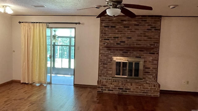 1410 Rock Creek Dr, Benton, AR 72019 - unfurnished living room featuring baseboards, wood finished floors, ceiling fan, a brick fireplace, and a textured ceiling