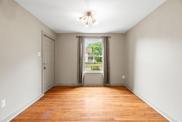 1720 W 19, Little Rock, AR 72202 - spare room featuring a chandelier, light wood-type flooring, and baseboards