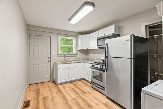 1724 W 19, Little Rock, AR 72202 - kitchen featuring stainless steel appliances, a sink, white cabinets, and light wood finished floors
