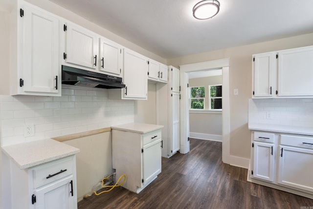 4300 W 16th St, Little Rock, AR 72204 - kitchen with under cabinet range hood, white cabinetry, tasteful backsplash, and dark wood-type flooring